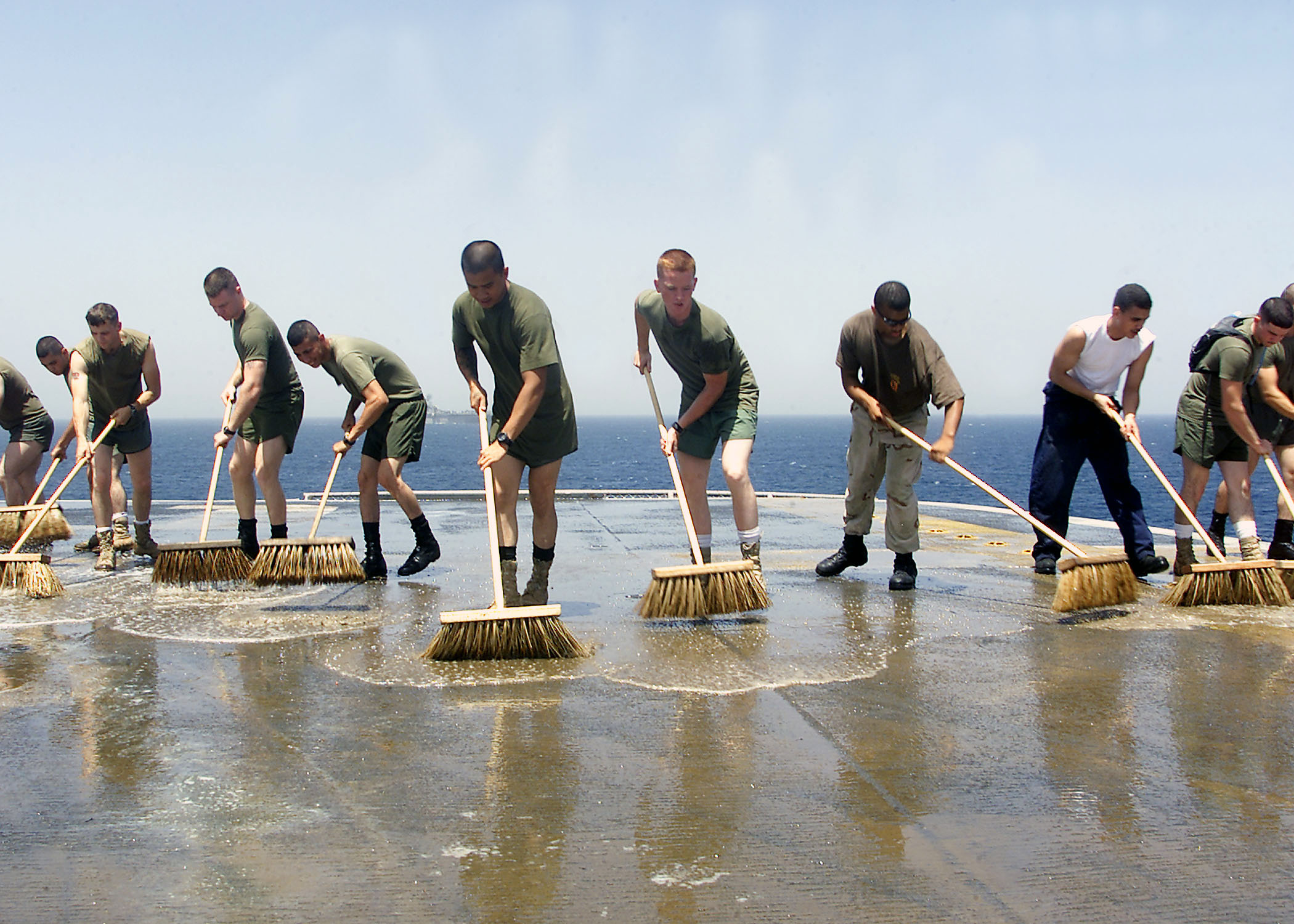US_Navy_030521-N-9109V-003_Sailors_and_embarked_Marines_flood_the_flight_deck_with_salt-water_solution,_scrub_brooms,_and_plenty_of_elbow_grease_in_a_mandatory_wash_down.jpg